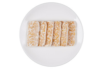 Slices of raw tempeh on a white plate isolated transparent