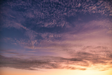 A beautiful sky tinted by the sun leaving vibrant shades of gold, pink, blue and multicolored. Clouds in the twilight evening and morning sky. Cloudy sky background in the evening, and during the day.