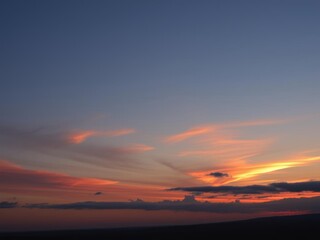 Vivid orange sunset sky with sun setting in the distance, creating a panoramic view, evening, colorful