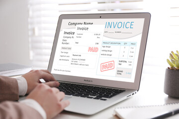 Woman using laptop to pay bills at home, closeup