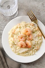 Delicious risotto with shrimps and cheese on grey table, top view