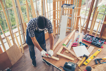 DIY craftsperson asian man working wood heap carpenter objects woodwork desk. Architect man hands use ruler measure hammer home improvement. Wooden builder carpenter repairing construction workshop