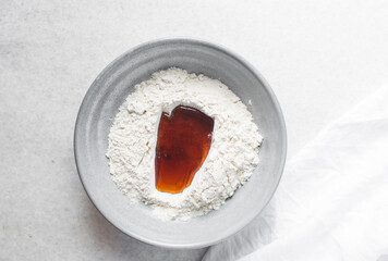 top view of mooncake dough being mixed, Overhead view of homemade mooncake dough in a grey bowl, process of making mooncakes for Lunar New Year and mid-autumn festival
