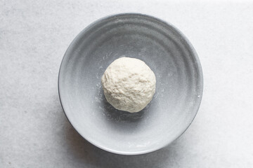 Overhead view of noodles dough in a grey bowl, top view of homemade biang biang noodles, process of making hand pulled noodles