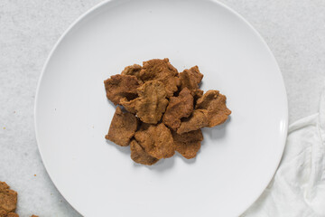 Overhead view of kuli-kuli on a white plate, top view of nigerian groundnut cakes on a plate