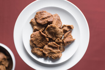 Overhead view of kuli-kuli on a white plate, top view of nigerian groundnut cakes on a plate