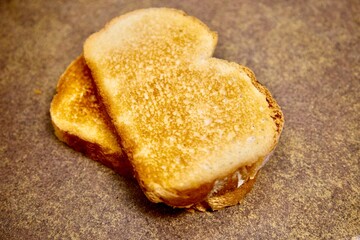 two slices of crispy toast on a brown textured surface