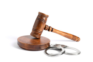 Handcuffs and judge's gavel isolated on white
