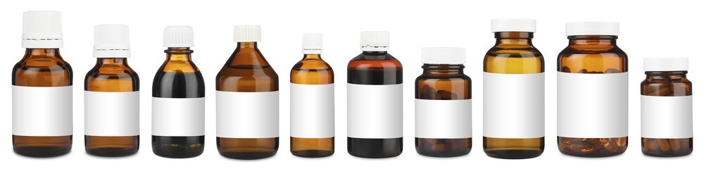 Many different glass bottles with labels isolated on white