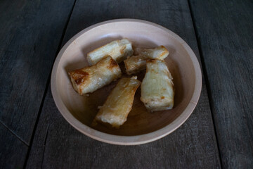 Fried cassava food served on a wooden bowl