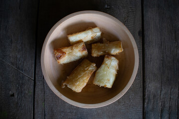Fried cassava food served on a wooden bowl