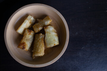 Fried cassava food served on a wooden bowl