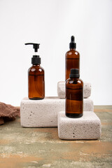 Amber Glass Bottles with Pump, Dropper, and Screw Caps on Concrete Blocks