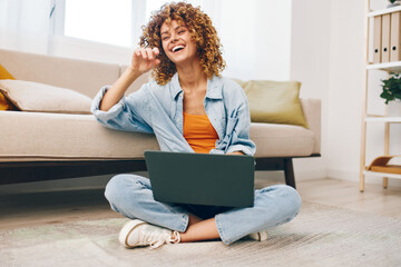 Smiling woman working with laptop in cozy home office, surrounded by modern technology and...