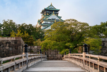 Fototapeta premium Osaka Castle from the side of the Gokuraku-bashi Bridge over the Inner Moat on a sunny autumn morning, Osaka, Japan