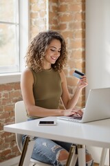 Young Woman Shopping Online with Credit Card at Modern Office Workspace