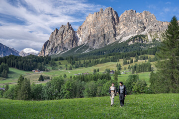 Couple enjoy view of Cortina D Ampezzo mountains landscape Dolomites, Italy.