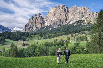 Fototapeta premium Couple enjoy view of Cortina D Ampezzo mountains landscape Dolomites, Italy.