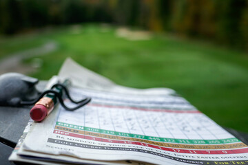 golf scorecard with pencil fairway in background