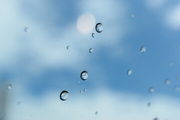 water drop on mirror with blue sky and white cloud background