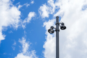 Bright Streetlight Illuminating Against a Blue Sky with White Clouds, Enhancing City Landscape and Urban Environment Atmosphere During Daylight Hours