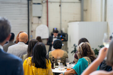 wedding ceremony celebrating marrage, with a wedding party crowd taking photos and videos of the party dancing and watching