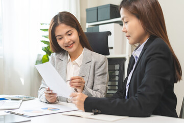 Fototapeta premium Business meeting, asian group woman brainstorm analysis on graph data of cost plan or document, paperwork and discussing in board room on table at office. People working together, financial advisor.