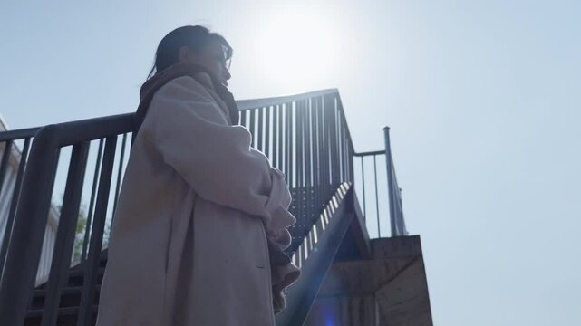 Woman holding a book and thinking in the sun