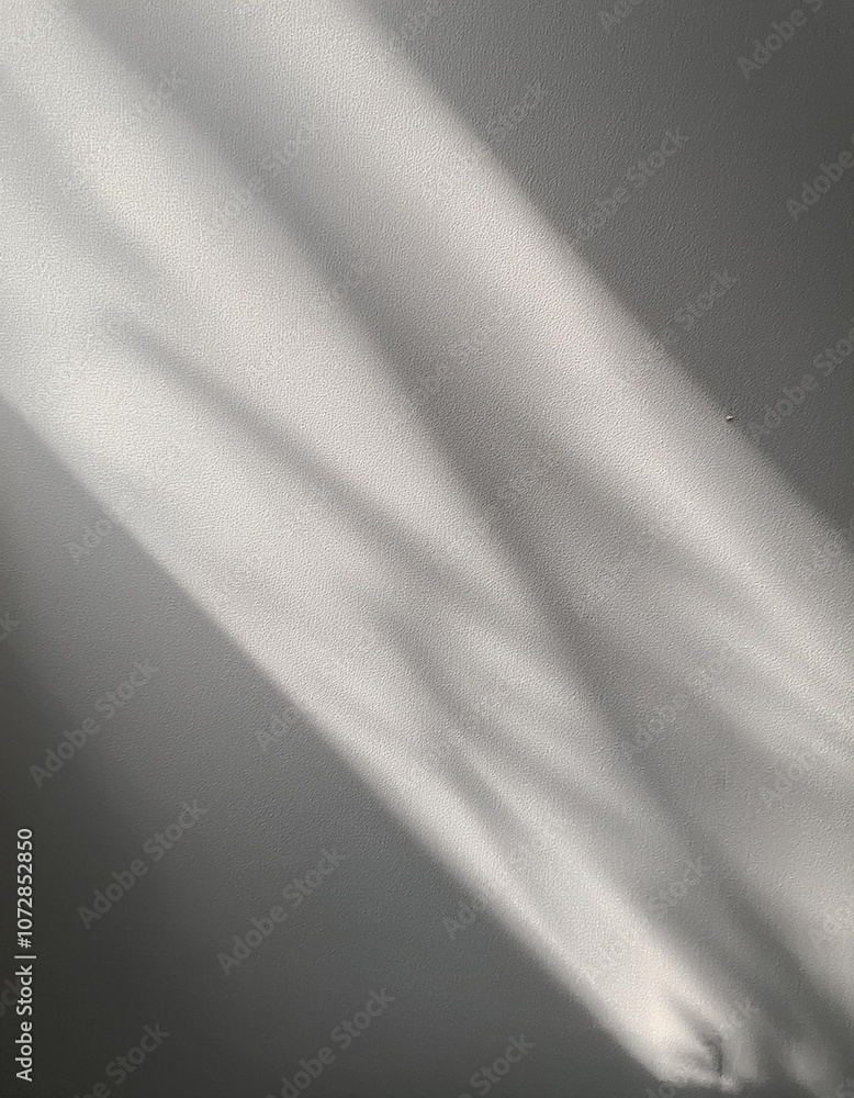 Aufkleber minimalist design with a textured wall and a shadow cast by soft sunlight, creating a monochromatic 