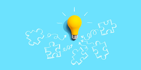 Jigsaw puzzle with a yellow light bulb - flat lay