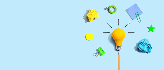 Brainstorming concept with a light bulb and school supplies