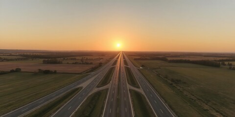 Fototapeta premium Beautiful sun rising over a scenic rural landscape with asphalt highways cutting through the countryside, sunrise, sky