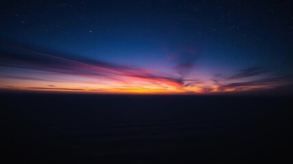 Fototapeta premium Deep blues and purples dominate the sky as a stunning sunset gives way to starry darkness over vast ocean, sand, sky