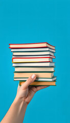 Hand with stack of books on blue background isolated with white highlights, png