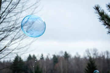Naklejka premium A single blue bubble hovering in mid-air, surrounded by a soft white background, dreamy, minimalist