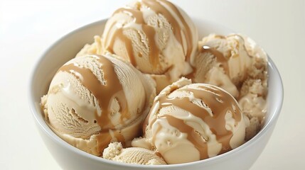Three scoops of vanilla ice cream in a bowl with caramel sauce.
