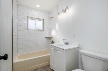 Interior view of a new, renovated empty white bathroom with modern light bulbs