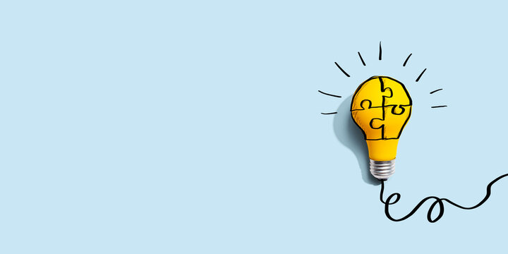 Jigsaw puzzle with a yellow light bulb - Flat lay