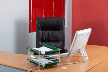 office with computer, leather chair, red blinds, stationary acrylic office file organizer for papers, no people