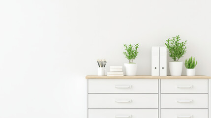 A modern white dresser with wooden top displays potted plants, stationery, and books, creating fresh and organized workspace