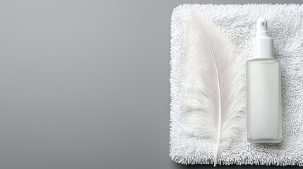A delicate feather resting on a soft, white towel beside a bottle of hypoallergenic lotion, symbolizing gentleness and suitability for sensitive skin.