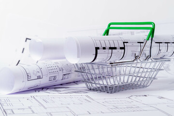 Construction plan in grocery basket. House design project. Miniature house in a basket..