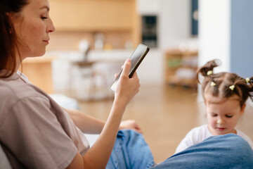 Mother with a smartphone and not paying attention to her child