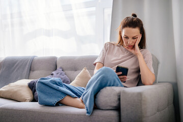 Female using smartphone at home internet watching videos, social networks
