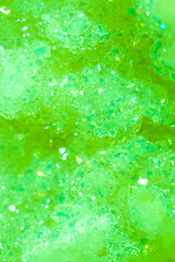 Green crystal mineral stone. Gems. Mineral crystals in the natural environment. Texture of precious and semiprecious stones. Seamless background with copy space colored shiny surface of precious stone