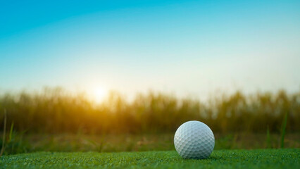 olf ball on green grass in the evening golf course with sunshine background.