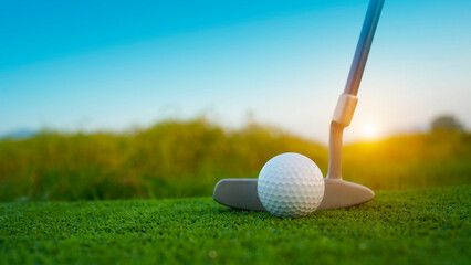 Golf clubs and balls on a green lawn in a beautiful golf course with morning sunshine.