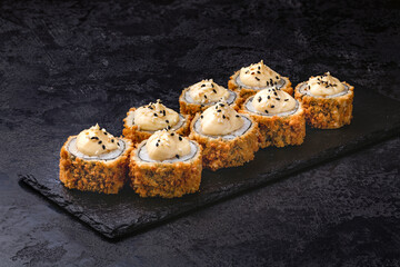 Japanese rolls, sushi fried tempura salmon and cream cheese on black background.