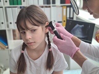 A healthcare professional examining a child ear with an otoscope