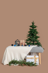 Soft bench with Christmas presents and fir tree on brown background